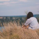 Person sitting peacefully in nature and taking a break to clear the mind