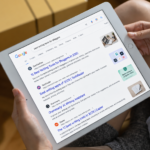 Person researching blog topics on a tablet using Google search